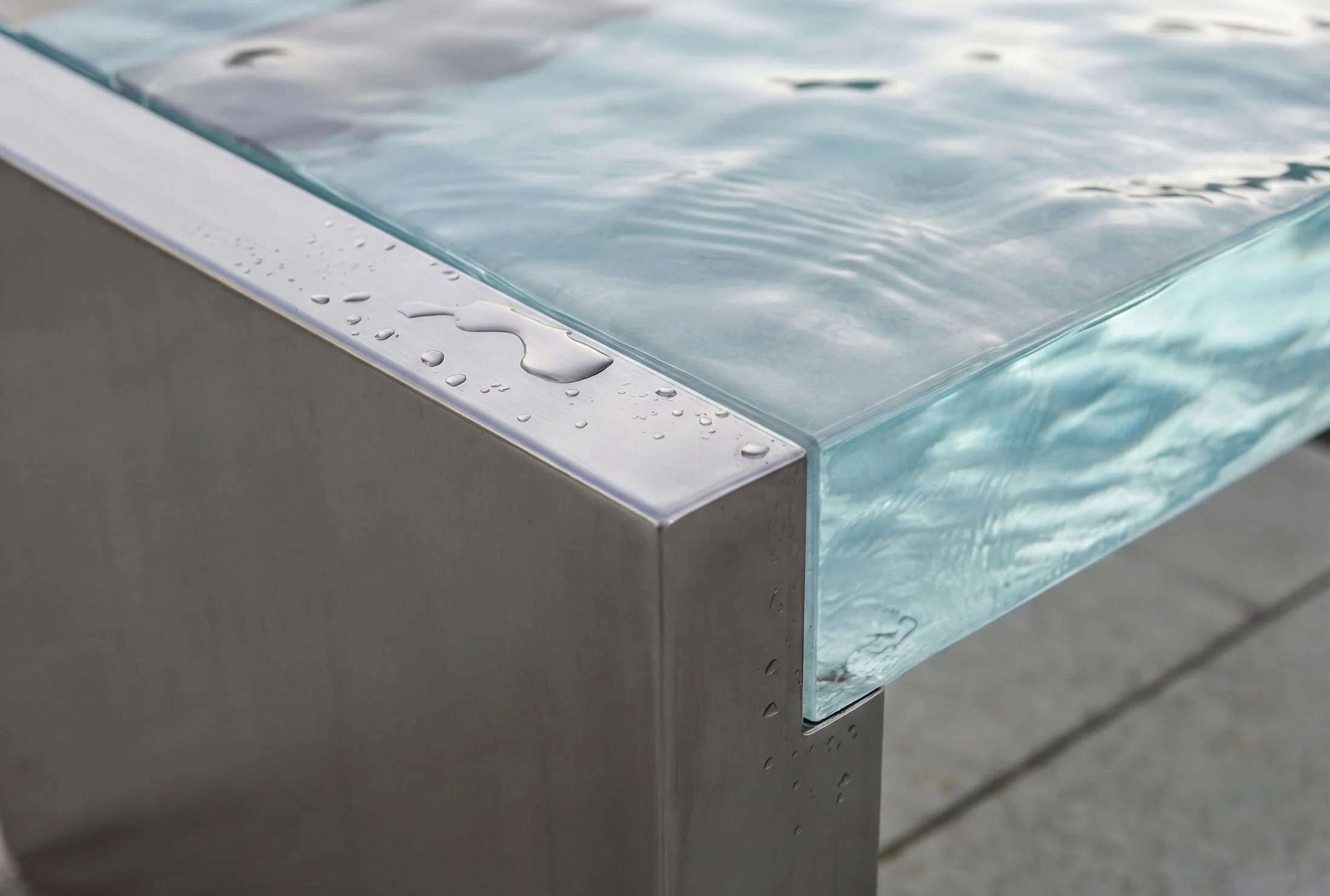 Acero inoxidable 316L y acrílico de colada con textura de agua: las gotas resbalan sobre el metal liso sin quedarse